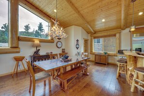A wooden interior with a dining table, benches, a chandelier, and a kitchen area. - 7 Min to Slopes! 3BD 2.5BA 5 Beds + Sofa Bed Cabin (Big Bear)