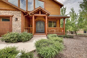 A log cabin with a stone foundation, a front porch, and a large wooden door. - 7 Min to Slopes! 3BD 2.5BA 5 Beds + Sofa Bed Cabin (Big Bear)