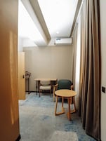 Una habitación de hotel con una cama, un escritorio, una silla y una mesita.