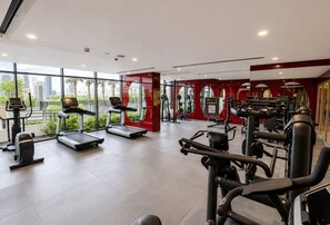 A gym with treadmills, elliptical machines, and weightlifting equipment. - HAVN - Studio in JVC with Pool View (Dubai)