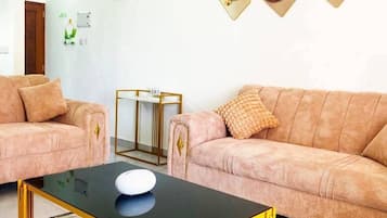 Een woonkamer met twee banken, een salontafel en wanddecoratie.
