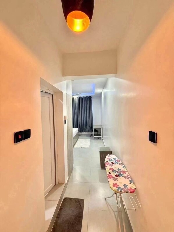 A hallway with a bench, a door, and a light fixture.
