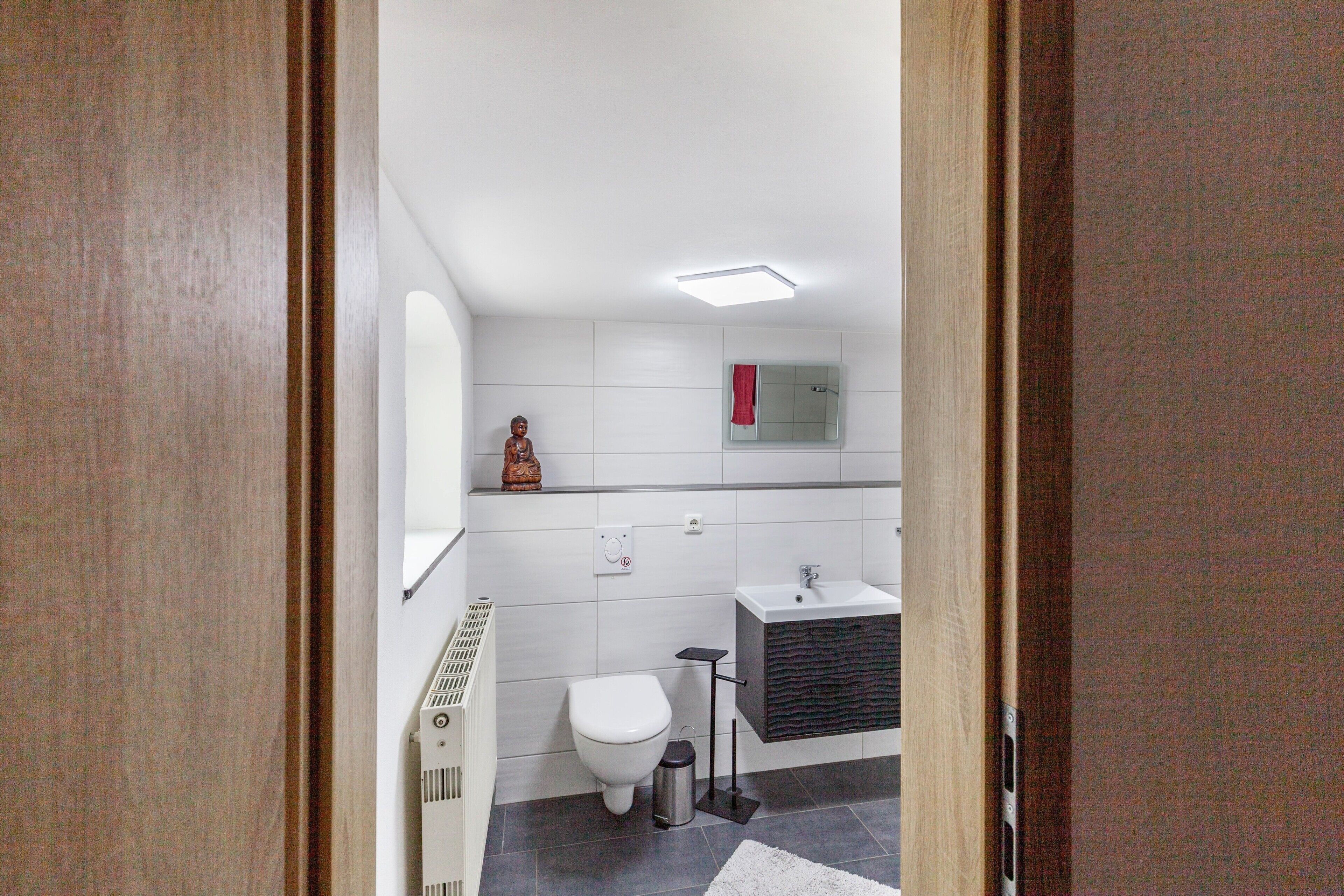 Een moderne badkamer met toilet, wastafel en douche.