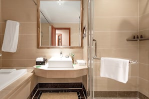 Un baño moderno con una bañera, un lavabo con espejo y una zona de ducha.