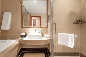 Un baño moderno con una bañera, un lavabo con espejo y una zona de ducha.