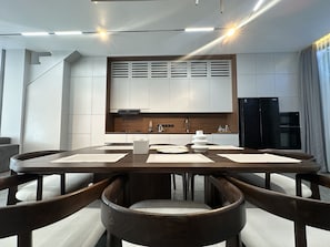 A modern kitchen with white cabinetry, a built-in stove, and a black refrigerator. - Modern 2BR Villa Umalas Great Location (Umalas)