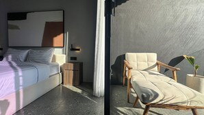 Un dormitorio moderno con cama, mesita de noche y un cuadro abstracto grande.
