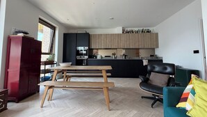 Eine moderne Küche mit Holzschränken und einem Essbereich mit Holztisch und -stühlen.