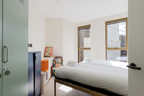 Ein Schlafzimmer mit einem Bett, einem Kleiderschrank, einem Fenster und einem Bücherregal.