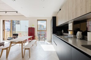Eine moderne Küche mit großem Fenster, einem Essbereich mit einer Bank und einem roten Schrank.