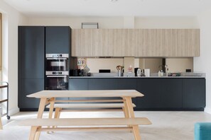 A modern kitchen with a built-in oven, a microwave, and a coffee maker. - Stylish Canal Side 2BDR Flat with Private Balcony (Greater London)