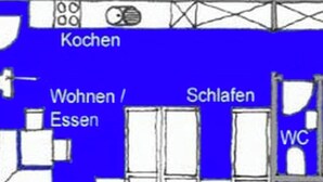 Ein Grundriss mit Küche, Wohn-/Essbereich, Schlafzimmern und einer Toilette.