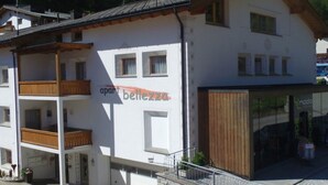 Ein zweistöckiges Gebäude mit einem Balkon im Erdgeschoss und einem Geschäft auf der rechten Seite.