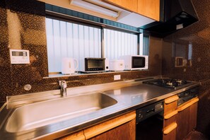 Una cocina moderna con electrodomésticos de acero inoxidable, un lavamanos doble y armarios de madera.