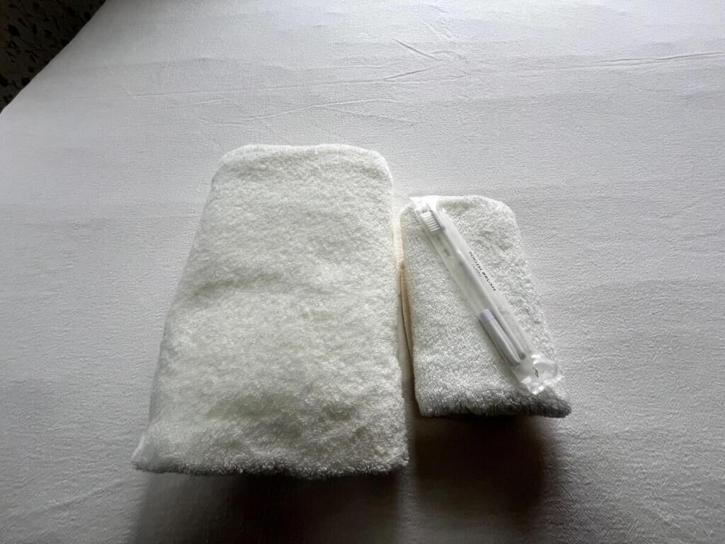 Two folded white towels on a flat surface.