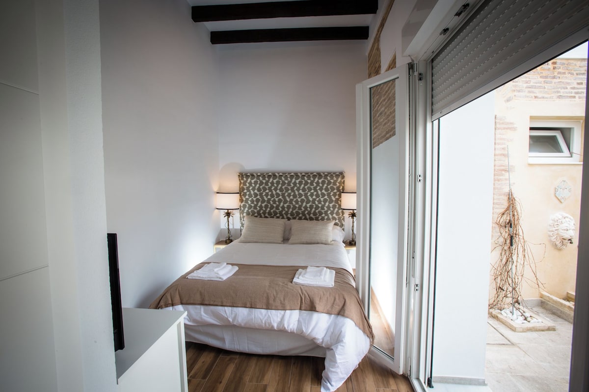 Una camera da letto con un letto, lampade sui comodini, una finestra e vista sull'esterno.
