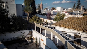 A rooftop terrace with a view of the cityscape, including a church tower. - Alijar Casa Boutique (Castilleja de la Cuesta)
