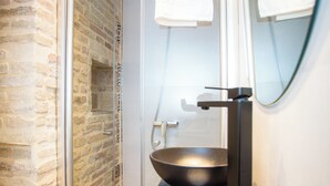 A bathroom with a glass shower enclosure, a black sink, and a mirror with a towel hanging on it. - Alijar Casa Boutique (Castilleja de la Cuesta)