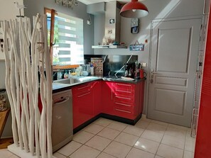 Eine Küche mit roter Arbeitsplatte, Edelstahlgeräten und einem weißen Schrank.