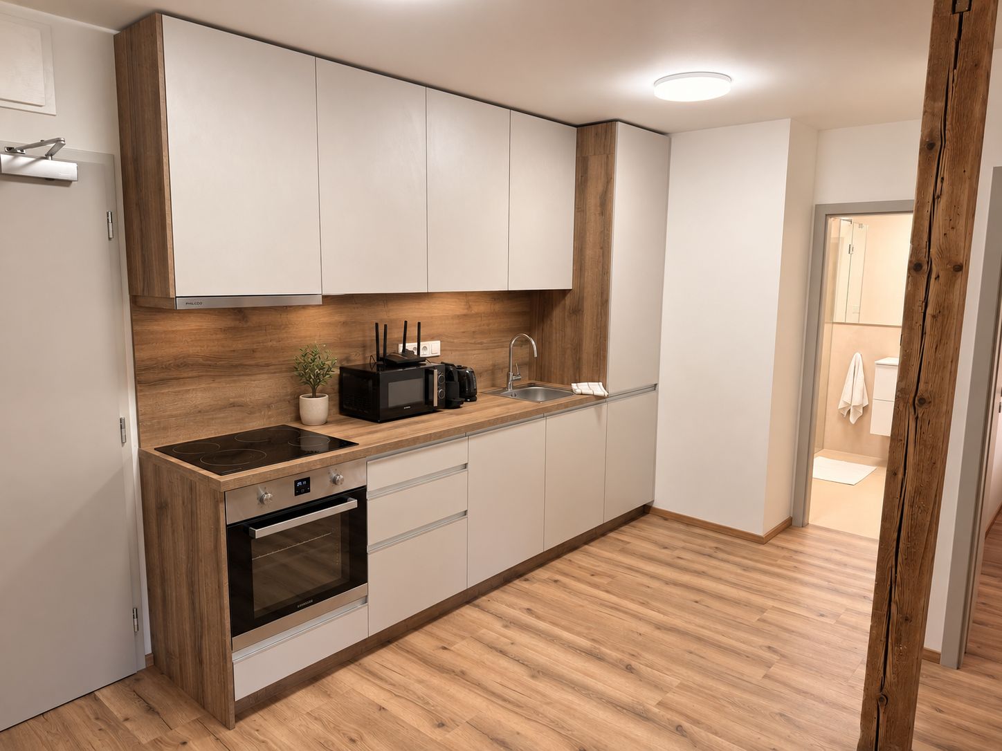 Eine moderne Küche mit Backofen, Mikrowelle und Spüle.