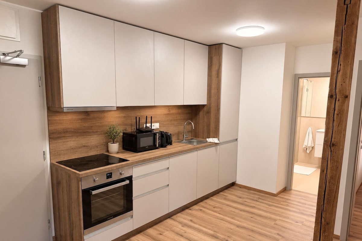 Una cocina moderna con horno empotrado, microondas y lavamanos.