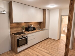A modern kitchen with a built-in oven, a microwave, and a sink.