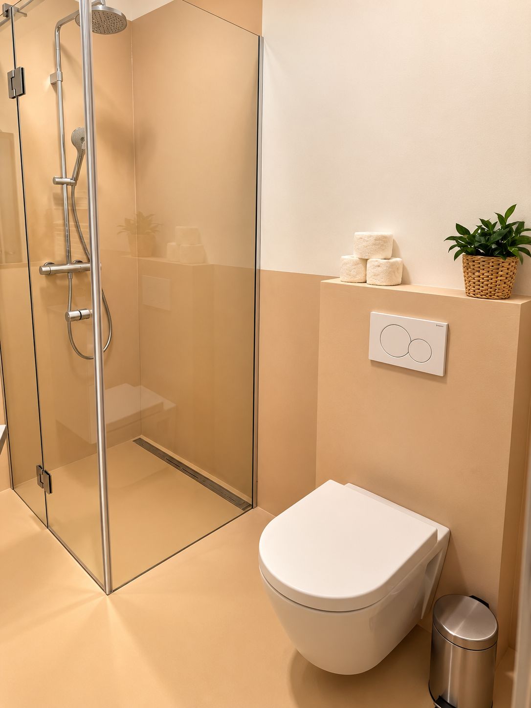 A modern bathroom with a glass-enclosed shower, a white toilet, and a small trash bin.