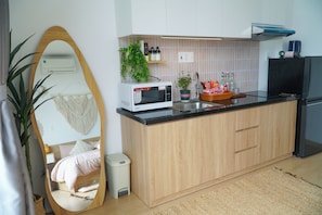 A modern kitchen with a microwave, sink, and refrigerator. -  Babo Homestay 1 Da Nang (Da Nang)