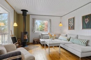 Ein gemütliches Wohnzimmer mit einer Couch, einem Couchtisch und einem Kamin.