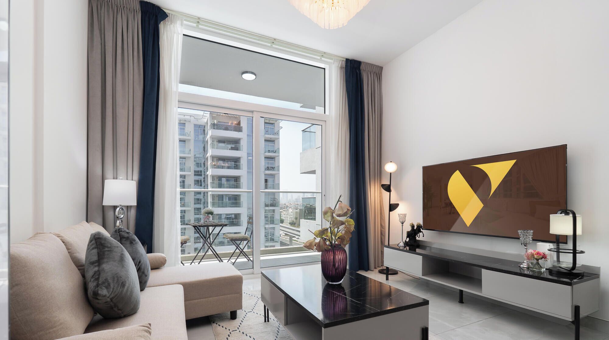 A modern living room with a sofa, coffee table, and a large window with curtains.