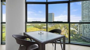 Ein Eckzimmer mit großem Fenster, einem Tisch und zwei Stühlen.