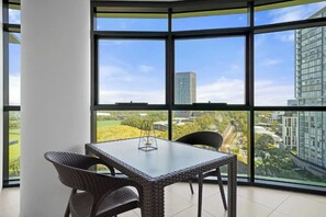 Ein Eckzimmer mit großem Fenster, einem Tisch und zwei Stühlen.