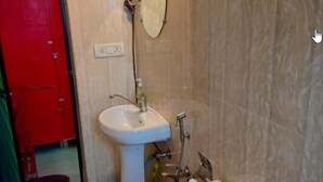A bathroom with a toilet, sink, and shower. - Mitra Hostel (Arambol)
