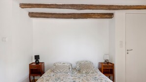 A bedroom with a bed, two nightstands, a door, and exposed wooden beams on the ceiling. - "Chambre Terrasse" Guest Room with Shared Terrace, Garden, and Wi-Fi (La Possonnière)