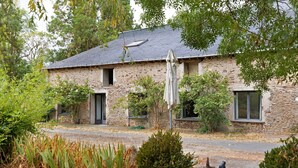 A stone building with a sloped roof, a front door, and a window. - "Chambre Terrasse" Guest Room with Shared Terrace, Garden, and Wi-Fi (La Possonnière)