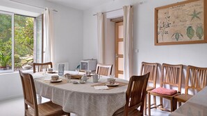 A dining area with a round table, chairs, and a vintage radio. - "Chambre Terrasse" Guest Room with Shared Terrace, Garden, and Wi-Fi (La Possonnière)