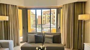 A corner seating area with a sofa, cushions, and a vase of flowers. - Vilamoura Residences | Swimming Pools | Gym | 6 People (Vilamoura)