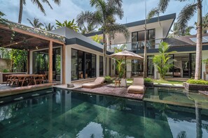A modern house with a swimming pool, outdoor furniture, and lush greenery. - Villa Yuka (Ubud)