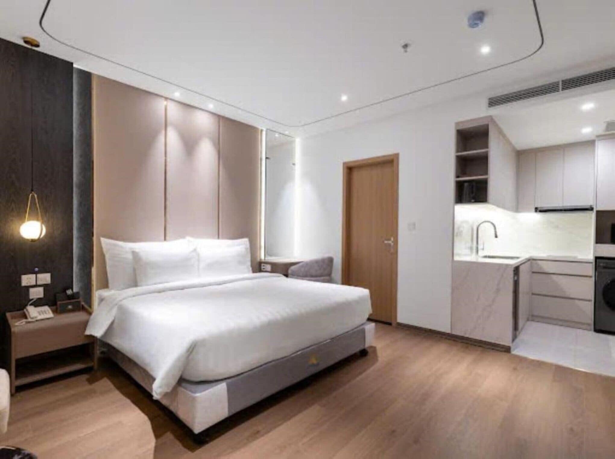 Une chambre moderne avec un grand lit, une table de chevet et une armoire intégrée.