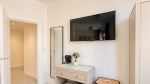 Une salle de bain avec un meuble-lavabo, un miroir et une poubelle.