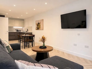 A modern living room with a sofa, a dining table, and a kitchen in the background. - Modern 1BR - Sleeps 4 - Free Parking - Manchester (Manchester)