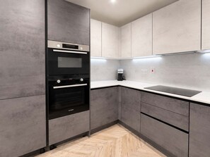 A modern kitchen with a built-in oven, a coffee maker, and a sink. - Modern 1BR - Sleeps 4 - Free Parking - Manchester (Manchester)