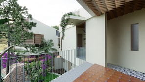 A modern outdoor area with a staircase, a stone wall, and a metal railing. - Hatha House (Tabanan)