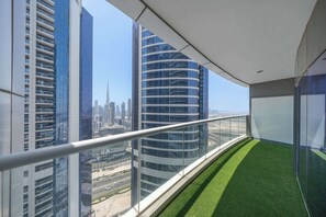 Ein Balkon mit Blick auf hohe Gebäude und eine entfernte Stadtlandschaft.