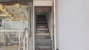 Eine Treppe führt zu einer oberen Etage mit einem Glastür-Eingang.