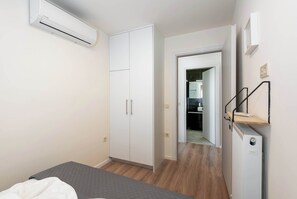 Une chambre à coucher comprenant un lit, une armoire et un appareil de climatisation.