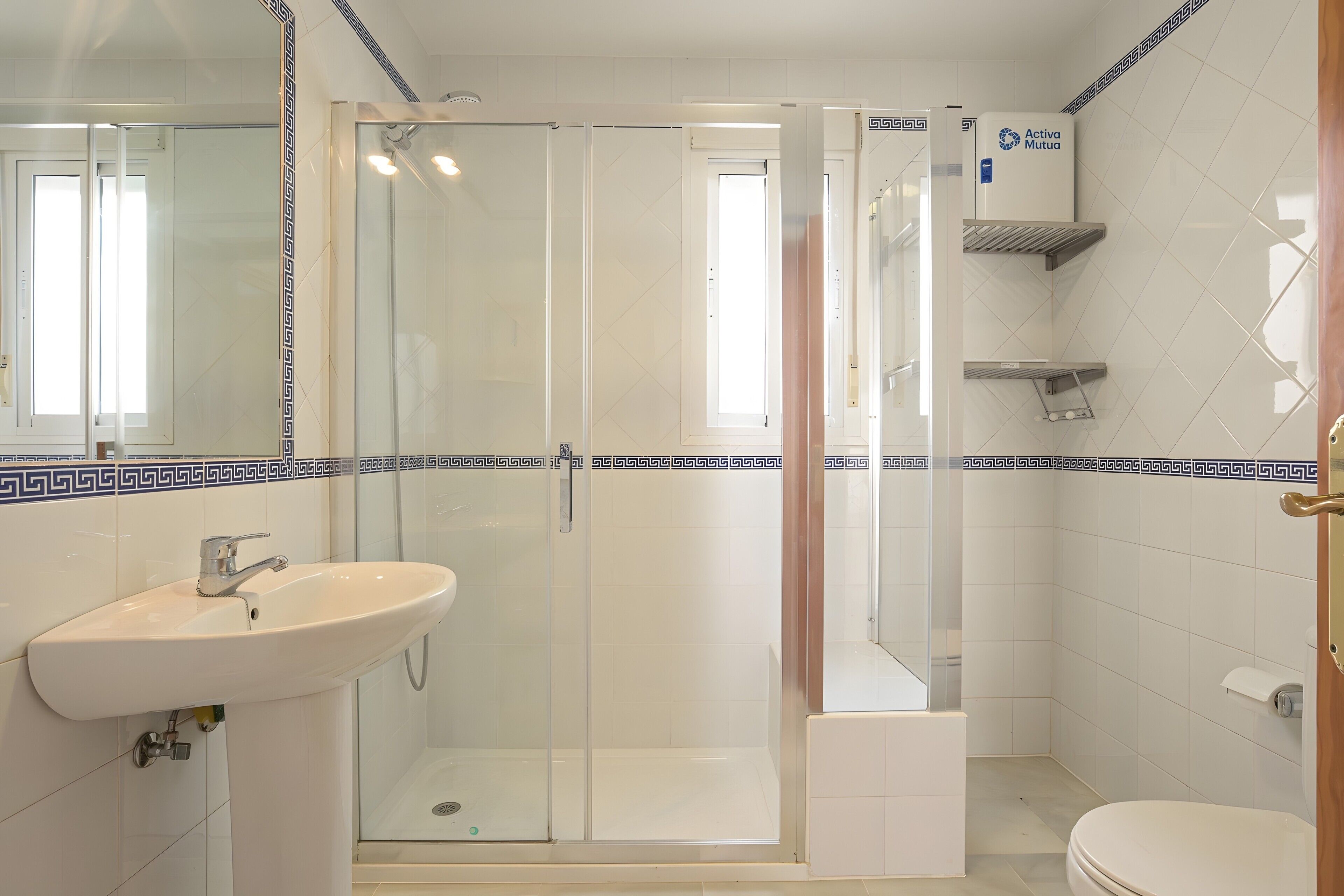 Ein Badezimmer mit Duschkabine, Waschbecken und Toilette.