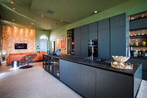 A modern kitchen with a large island, built-in appliances, and a seating area with a sofa and chairs.