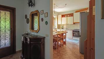 A kitchen with wooden cabinets, a dining table, and a chandelier.