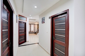 A corridor with two wooden doors, each marked with a number. - Super Townhouse by Cosmo Mall Zirakpur (Zirakpur)